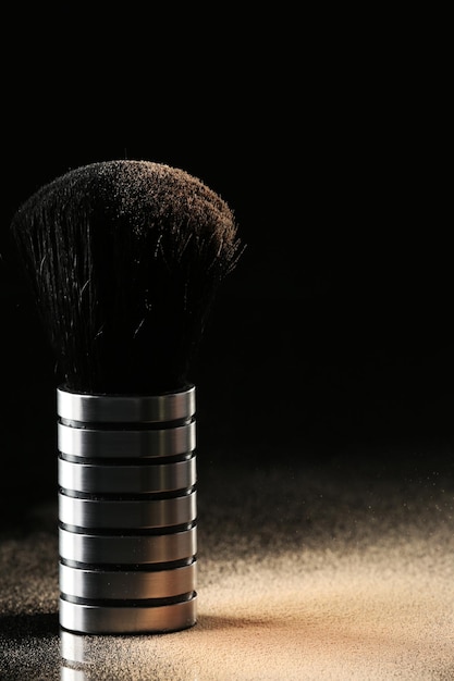 Photo make up brush and powder on black background