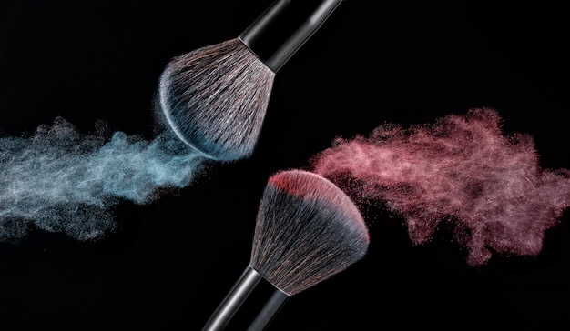 Make up brush with powder splashes on black background