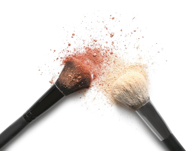 Photo make up brushes with brown and beige eye shadows on white background