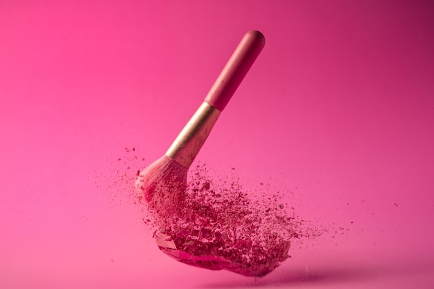 Make up brushes with powder splashes on pink