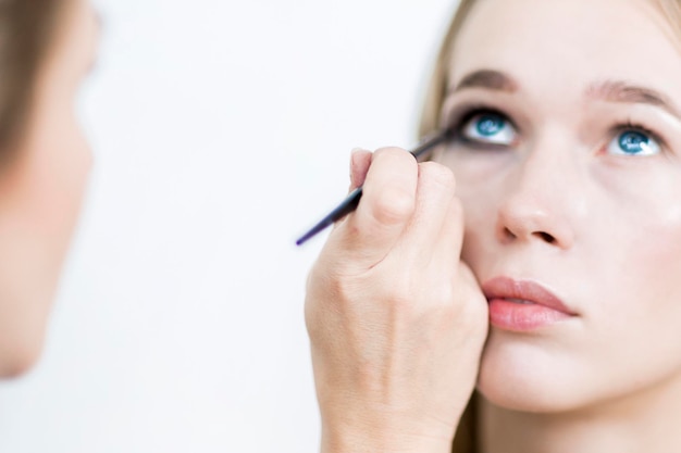 Foto make-up close-up make-up artiest zet oogschaduw op meisje