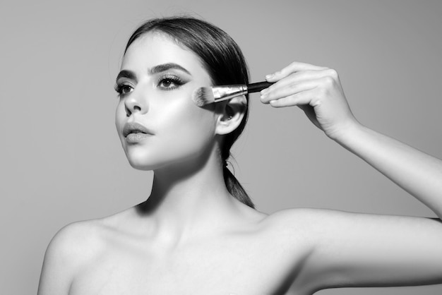 Make-up en cosmetica vrouw met make-up borstel huidverzorging gezicht schoonheidsbehandelingen