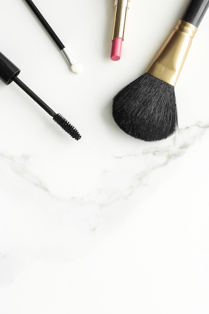 Make-up- en cosmeticaproducten op marmeren flatlay-achtergrond