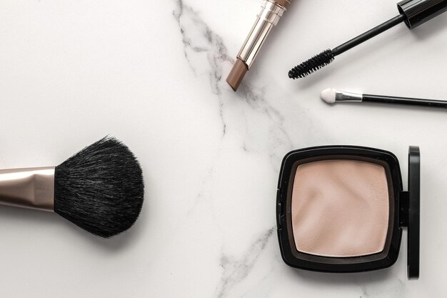 Make-up- en cosmeticaproducten op marmeren flatlay-achtergrond