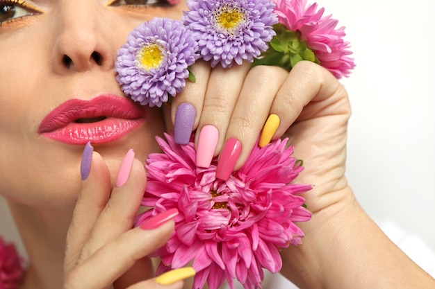 Make-up en manicure op nagels van een meisje met asters.