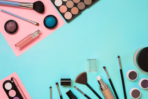 Набор основных средств для макияжа профессиональных кистей для макияжа, кремов и теней в банках на синем фоне