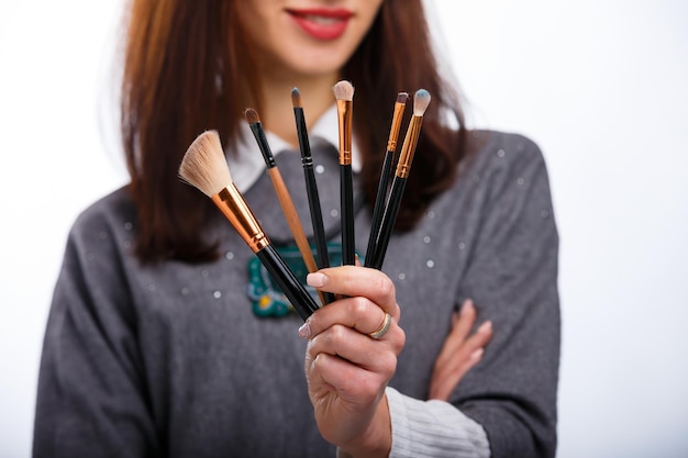 Make-up kwasten in de handen van de vrouw Cosmetologie concept Bijgesneden foto