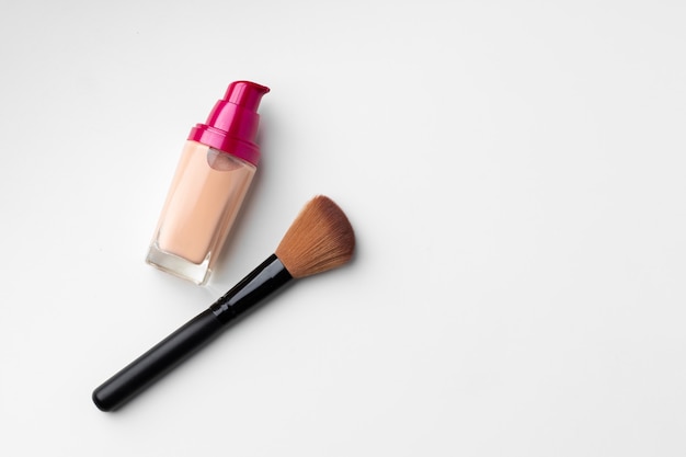 Make-up liquid foundation with brush on white surface