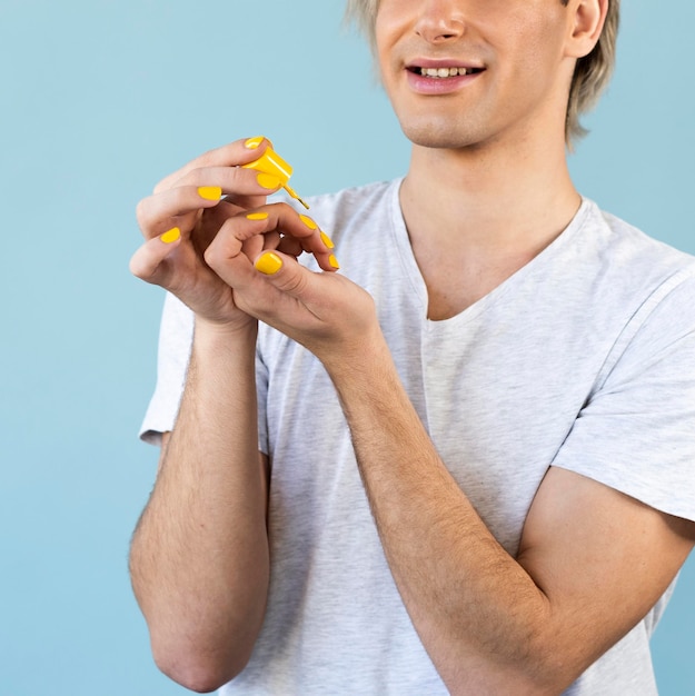 Uomo di trucco utilizzando smalto rosso