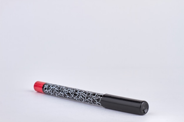 Составьте продукт, изолированные на белом. Новый красный карандаш для губ.