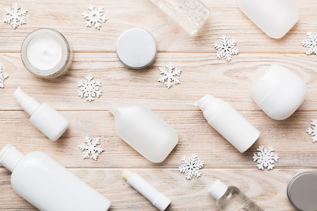 Make-up producten en kerstversiering op kleur achtergrond. Bovenaanzicht Nieuwjaar Beauty concept.