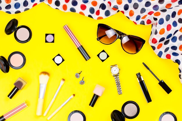 Make up products, jewelry, accessories on yellow