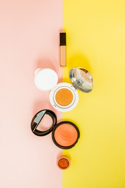 Make up products spilling on to a bright yellow and pink background