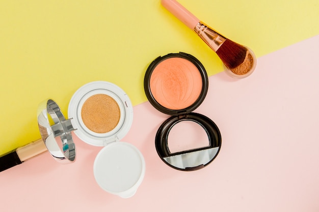 Make up products spilling on to a bright yellow and pink