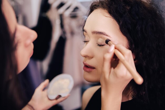 Make up talanted artist doing maquillage to woman