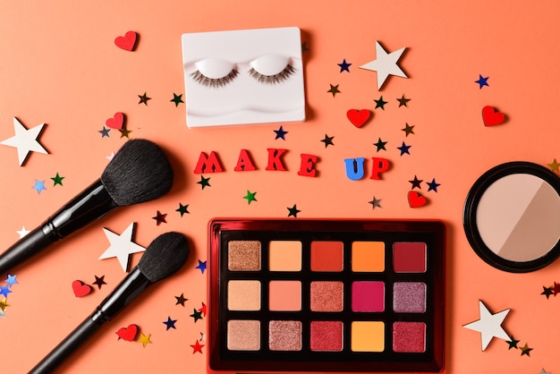 Photo make up text on an orange background. professional trendy makeup products with cosmetic beauty products