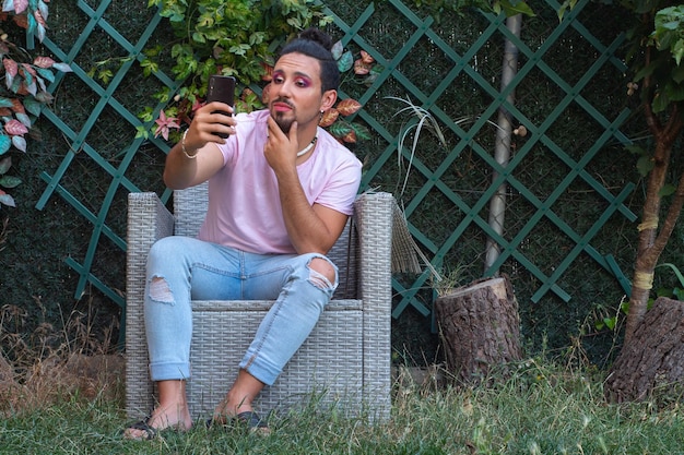 Make-up transsexual with a beard taking a selfie with her mobile