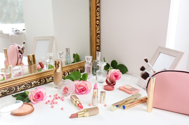 Make-upcosmetica met roze bloemen op kaptafel