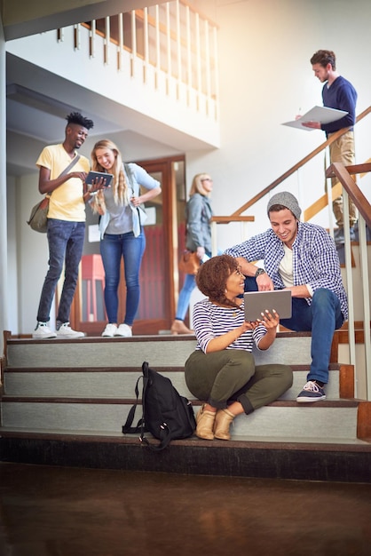 Make use of all the tools at your disposal Shot of a university students using a digital tablet on the staircase at campus