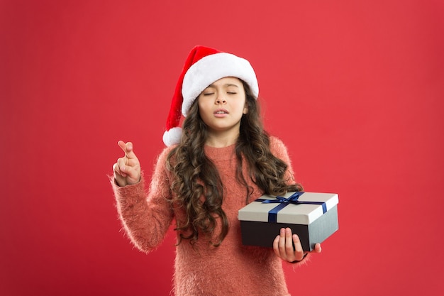 소원을 빌다. 내가 원하는 모든 크리스마스. 작은 아이는 크리스마스 전통을 즐깁니다. 선물 배달 서비스. 감성적인 아이. 어린 소녀는 선물 상자를 잡고 있습니다. 겨울 방학. 메리 크리스마스. 산타클로스 선물.