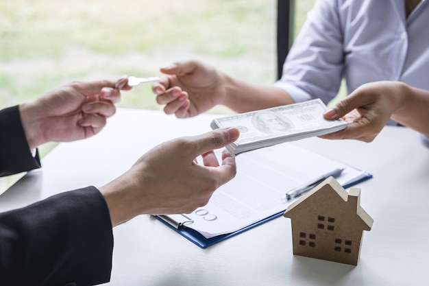 Foto makelaar die huissleutels geeft aan cliënt