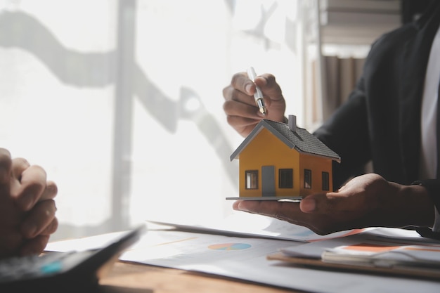 Makelaar in onroerend goed en klant ondertekenen contract om een huisverzekering te kopen of onroerend goed te lenen, een huisverzekering te huren of onroerend goed of onroerend goed te lenen