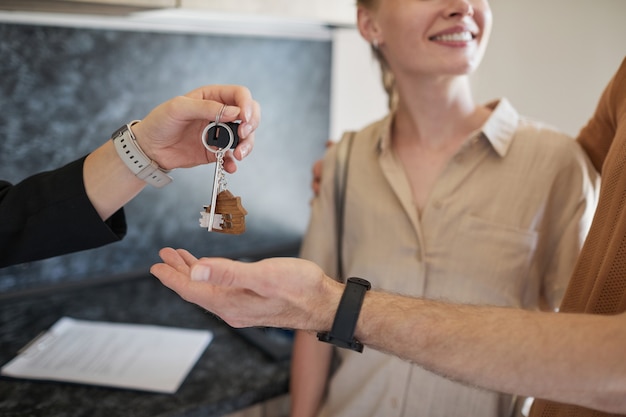 Makelaar in onroerend goed geven sleutels close-up