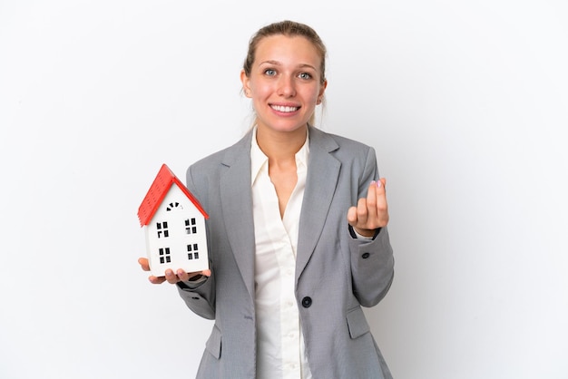 Foto makelaar vrouw met een speelgoed huis geïsoleerd op een witte achtergrond geld gebaar maken