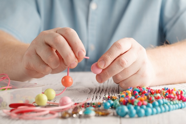 Maken van handgemaakte sieraden, vooraanzicht van mannelijke handen