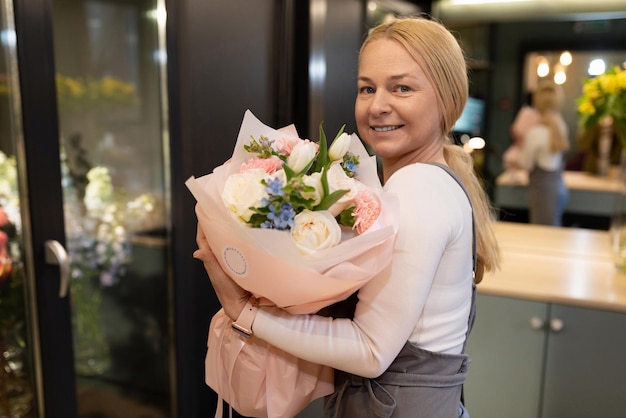 Creatore di composizioni floreali con un bouquet in mano