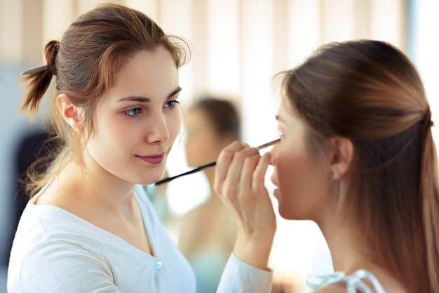 makeup artist applying eyeshadows with a brush