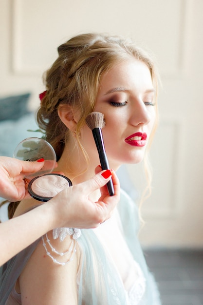 makeup artist doing makeup to the bride