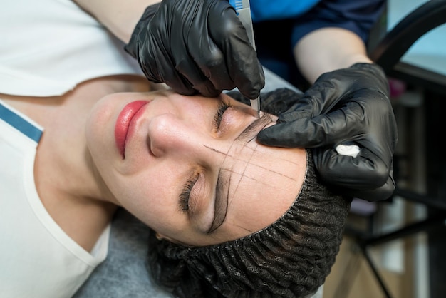 Photo makeup artist plucks eyebrows in a beauty salon professional makeup and cosmetology skin care