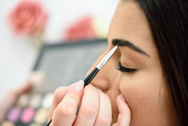 Makeup artist putting make-up on an woman's eyebrows