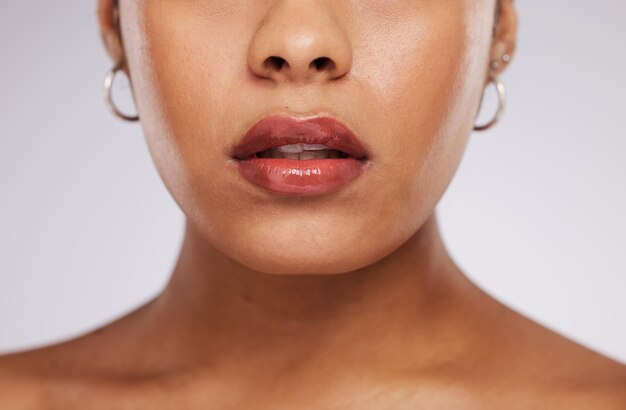 Foto trucco bellezza e bocca di donna con cosmetici per il benessere cura di sé e cura della pelle in studio salone spa di lusso e zoom del viso della ragazza per il trattamento del viso rossetto e glamour su sfondo bianco