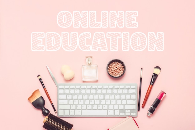 Photo makeup and beauty tools, keyboard on a pink surface. the concept of learning through the internet, the order of cosmetics in the online store. flat lay, top view