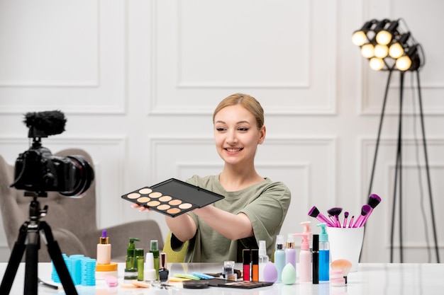Makeup blogger cute pretty young girl recording makeup tutorial on camera applying makeup