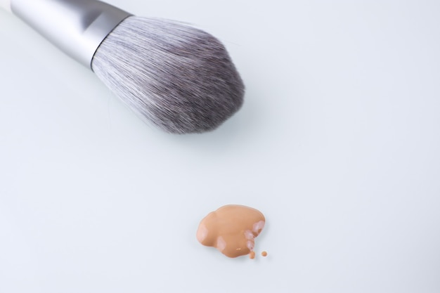 a makeup brush and a drop of Foundation for the face