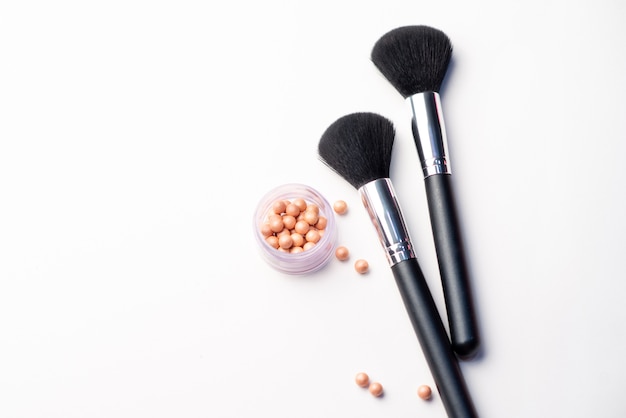 Makeup brush, flowers and blush on a white background. Beauty concept. Close-up with space for text