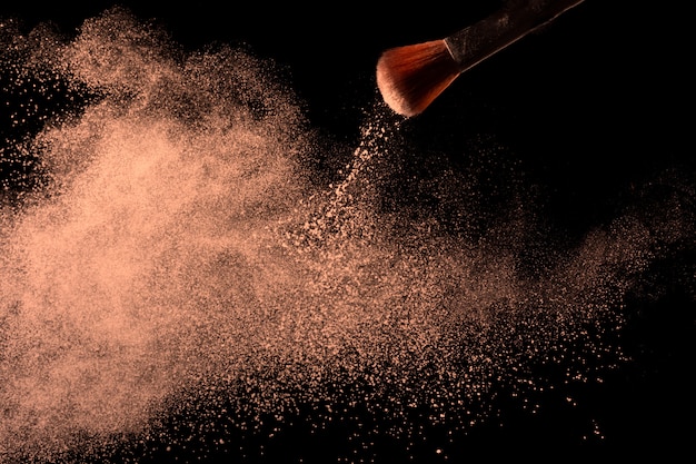 The makeup brush with beige powder foundation isolated.