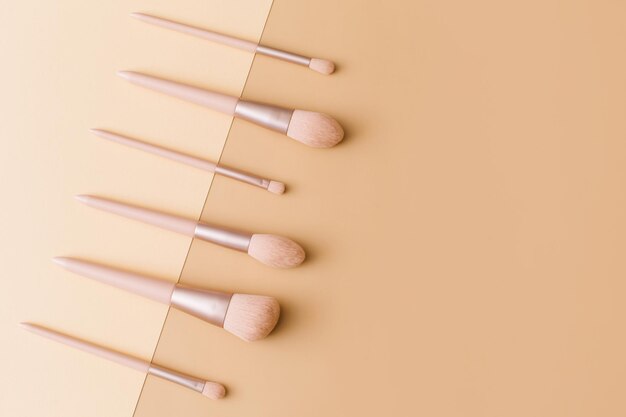 ベージュの背景のメイクアップブラシ 女性の美容アクセサリー フラットレイ トップビュー コピースペース