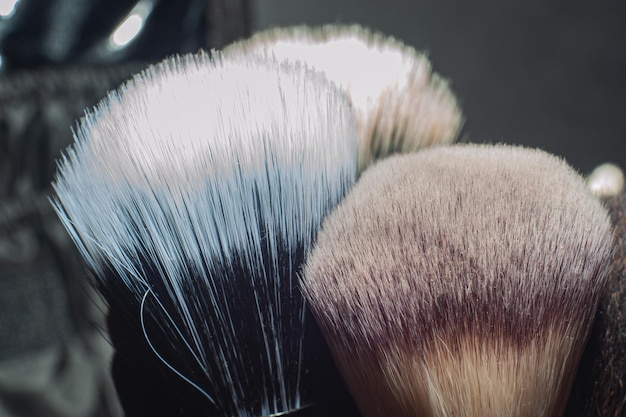 Makeup brushes on a black background with a place to insert\
text