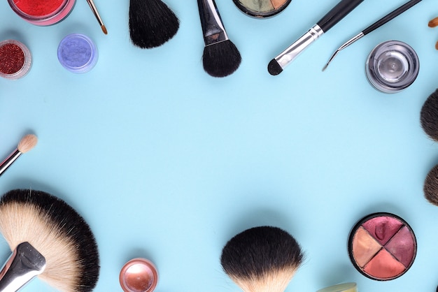 Makeup brushes on a blue background. Top view, flat lay, copy space