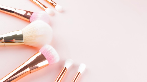 Photo makeup brushes on pink background set of golden makeup brushes concept woman beauty accessory