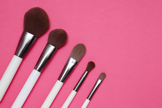 makeup brushes on a pink background