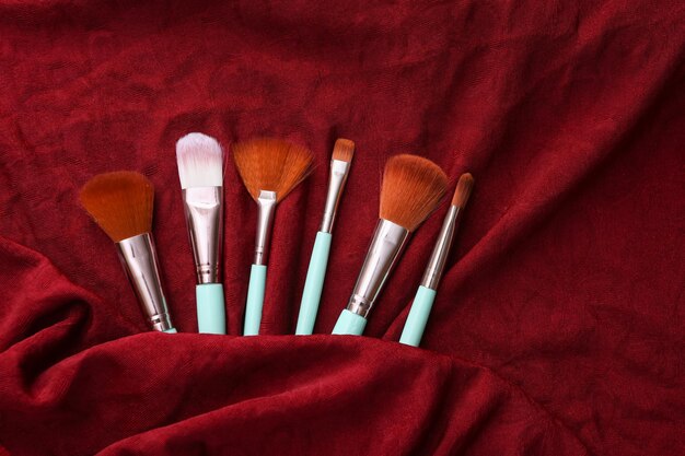 Makeup brushes on red silk background Beauty still life