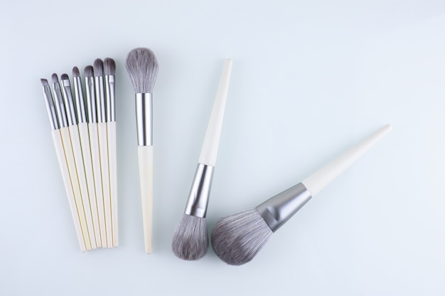 makeup brushes scattered on a white