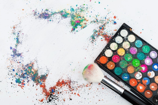 Makeup brushes on table with colorful powder. 