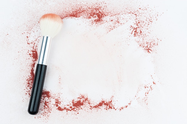 Makeup brushes on table with powder. 