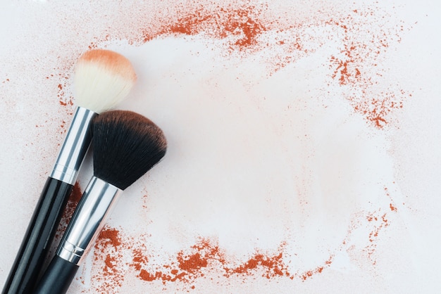 Makeup brushes on table with powder. 